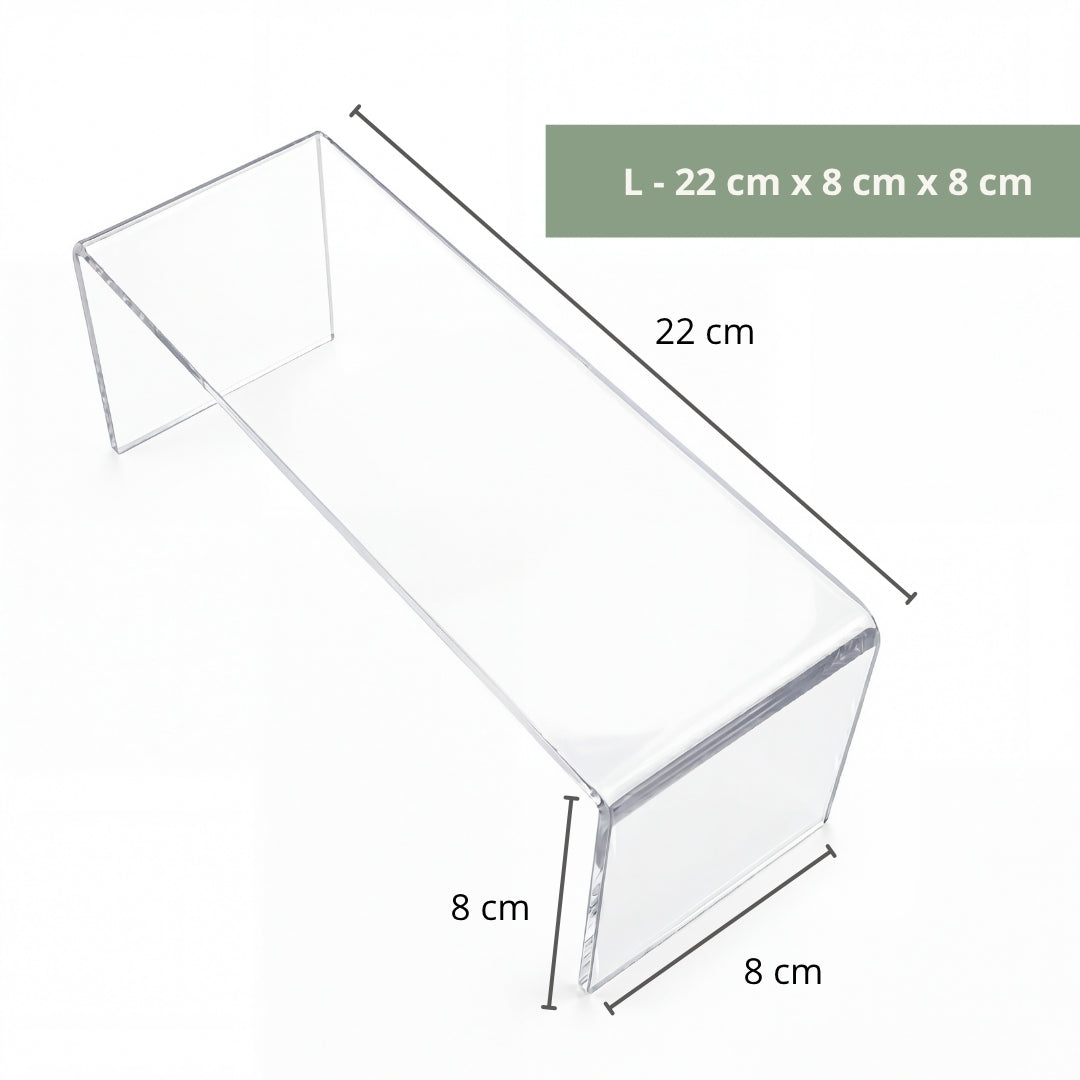 Clear acrylic riser with small sculpture on art display shelf