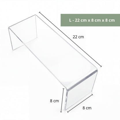 Clear acrylic riser with small sculpture on art display shelf